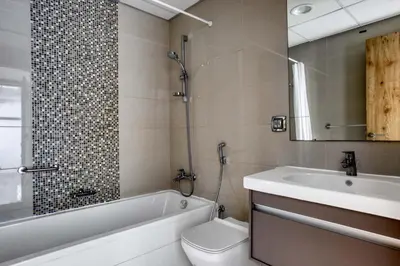 a bathroom with a tub and a toilet and a sink at Blueground Marina Pool Gym DXB-221 in Dubai