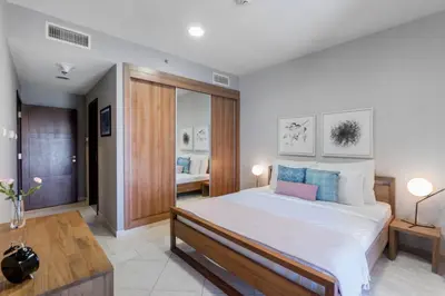 a bedroom with a large white bed with blue pillows at Blueground Marina Pool Gym DXB-237 in Dubai