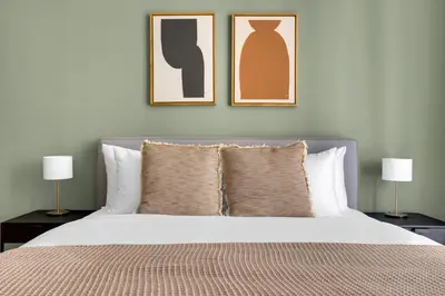 a bedroom with a bed with two lamps and two pictures at Blueground Duja Tower City View pool gym DXB-1108 in Dubai