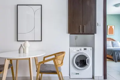 a kitchen with a table and a washing machine at Blueground The Royal Oceanic pool gym DXB-1152 in Dubai