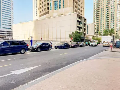 a street with cars parked on the side of the road at Blueground Marina Gate city view sauna gym DXB-1338 in Dubai