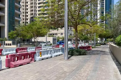a sidewalk with red and white benches on a city street at Blueground Downtown B Khalifa view pool DXB-645 in Dubai
