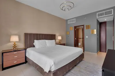 a bedroom with a large bed and two nightstands and two lamps at BellaVista - 29 Boulevard 2 Bedroom Downtown Fountain View in Dubai