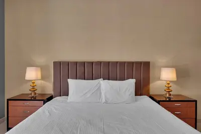 a bedroom with a bed with two lamps on night stands at BellaVista - 29 Boulevard 2 Bedroom Downtown Fountain View in Dubai