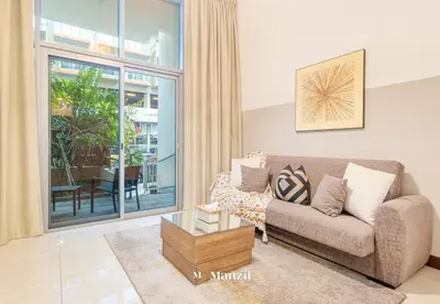 a living room with a couch and a large window at Manzil - Studio in JVC w Premium Amenities near Circle Mall in Dubai