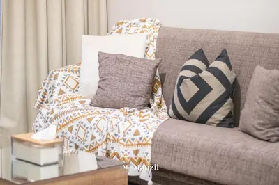 a living room with a couch with pillows at Manzil - Studio in JVC w Premium Amenities near Circle Mall in Dubai