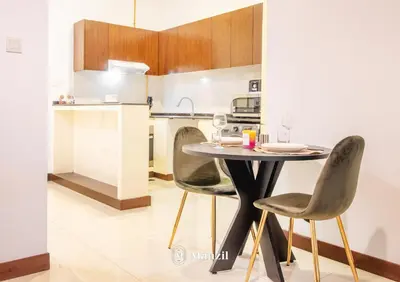 a kitchen with a table and chairs in a room at Manzil - Studio in JVC w Premium Amenities near Circle Mall in Dubai