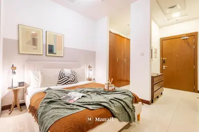 a bedroom with a large bed and a bathroom at Manzil - Studio in JVC w Premium Amenities near Circle Mall in Dubai