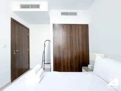 a bedroom with a bed and a wooden door at Luxury 3-Bedroom Duplex in Damac Hills & balcony in Dubai