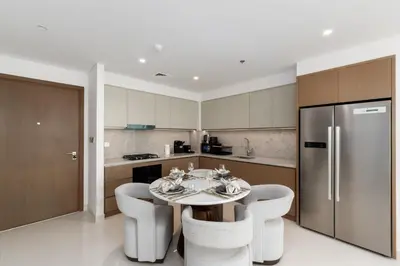 a kitchen with a table and chairs and a refrigerator at Beach Isle 2, Emaar Beachfront - Mint Stay in Dubai