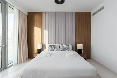 a bedroom with a large white bed with two lamps at Beach Isle 2, Emaar Beachfront - Mint Stay in Dubai