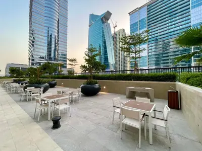 a patio with tables and chairs and tall buildings at Canal Vista - Home near Downtown - Awsesome views in Dubai