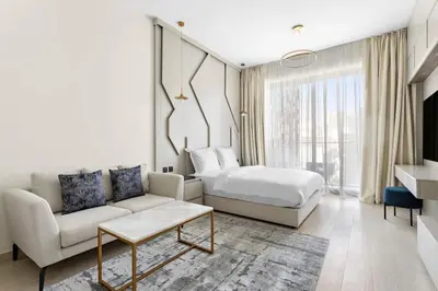 a living room with a bed and a couch and a bed and a room with at Cosy 1bedroom apartment with pool gym game room in Dubai
