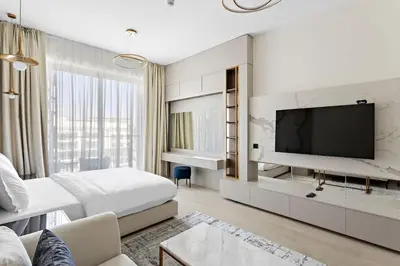 a hotel room with a large bed and a tv at Cosy 1bedroom apartment with pool gym game room in Dubai