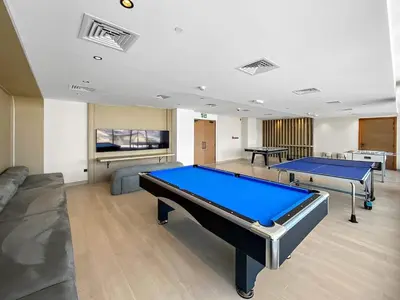 a large room with two ping pong tables in it at Cosy 1bedroom apartment with pool gym game room in Dubai