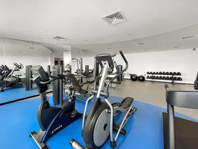 a gym with treadmills and elliptical machines at Cosy 1bedroom apartment with pool gym game room in Dubai