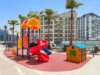 a playground with a slide and a slideintend at Cosy 1bedroom apartment with pool gym game room in Dubai