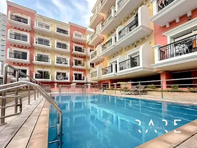 a swimming pool in front of a building at Rare Holiday Homes - Jumeirah Village Circle - Near Circle Mall - Botanica Tower - R105 in Dubai