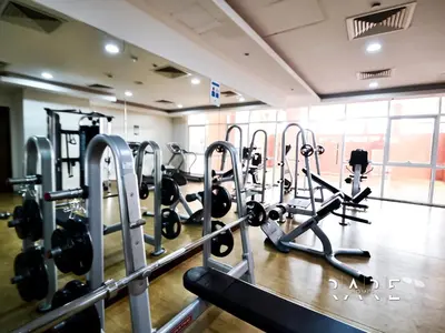 a gym with a row of tread machines at Rare Holiday Homes - Jumeirah Village Circle - Near Circle Mall - Botanica Tower - R105 in Dubai