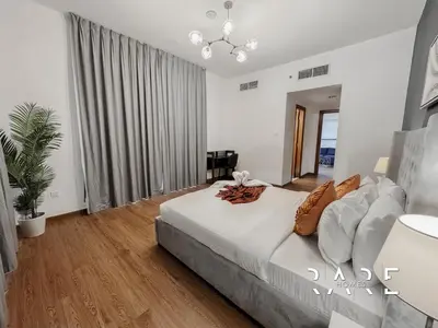 a bedroom with a large bed and a mirror at Rare Holiday Homes - Near Circle Mall - Lavender 1 - R309 - Jumeirah Village Circle in Dubai