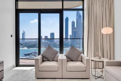 a living room with a couch and a large window at Dubai Marina Harbour View 2BR with Beach Access in Dubai