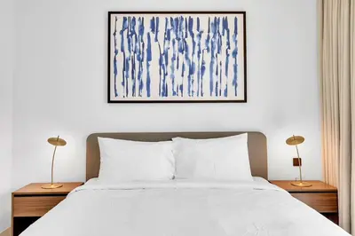 a bedroom with a white bed with two lamps on tables at Dubai Marina Harbour View 2BR with Beach Access in Dubai