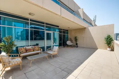 an outdoor patio with furniture and windows on a building at Stylish Apartment Huge Terrace Near Burj Khalifa in Dubai