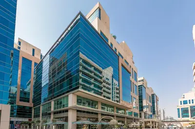a tall building with blue windows in a city at Stylish Apartment Huge Terrace Near Burj Khalifa in Dubai