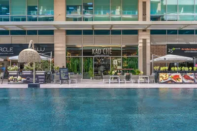 a hotel with a swimming pool in front of a building at Stylish Apartment Huge Terrace Near Burj Khalifa in Dubai