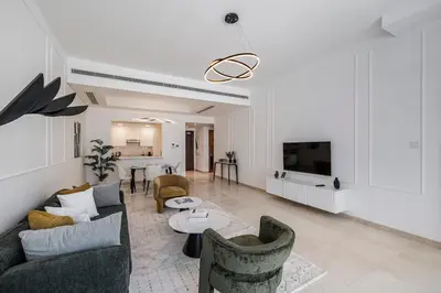 a living room with a couch and chairs and a tv at Stylish Apartment Huge Terrace Near Burj Khalifa in Dubai