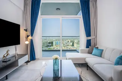 a living room with a couch and a large window at Homesgetaway -Spacious 1BR Apt in Pearlz by Danube in Dubai