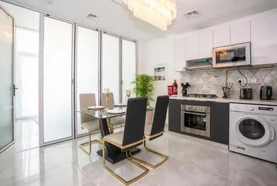 a kitchen and dining room with a table and a washing machine at Homesgetaway -Spacious 1BR Apt in Pearlz by Danube in Dubai
