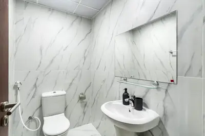 a white bathroom with a sink and a toilet at The Smart Concierge - Time Place in Dubai