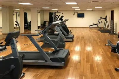 a gym with a row of treadmills and exercise bikes at The Smart Concierge - Time Place in Dubai