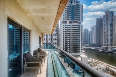 a balcony with chairs and a view of a city at The Smart Concierge - Time Place in Dubai
