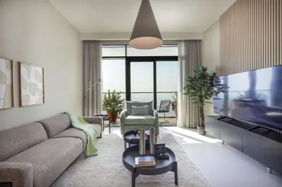 a living room with a couch and a tv at Stunning Palm View 1BR Apartment in Dubai Harbour in Dubai