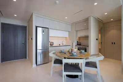 a kitchen with a table with chairs and a refrigerator at Stunning Palm View 1BR Apartment in Dubai Harbour in Dubai
