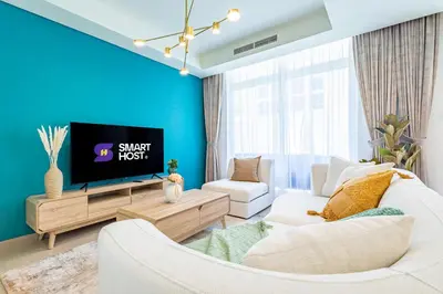 a living room with a white couch and a tv at Luxury 3BR 2storey Villa with Garden in Damac Hills in Dubai
