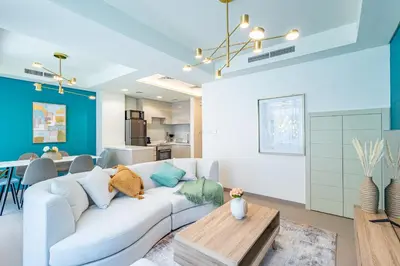 a living room with a white couch and a table at Luxury 3BR 2storey Villa with Garden in Damac Hills in Dubai