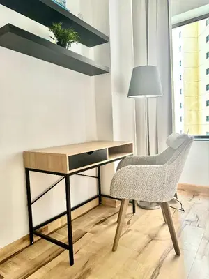 a desk and a chair in a room with a lamp at Stylish beachside apartment 3 beds in JBR in Dubai