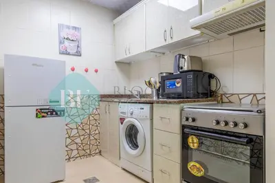 a kitchen with a washer and dryer in it at Bloomfields Deluxe Stu Jlt Near Metro in Dubai
