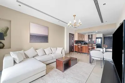 a living room with a white couch and a table at Close to Downtown - New 1 bedroom with parking in Dubai