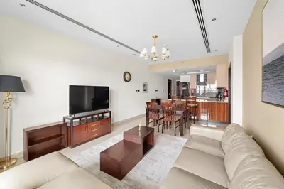 a living room with a couch and a television at Big 1 bedroom close to Downtown in Dubai