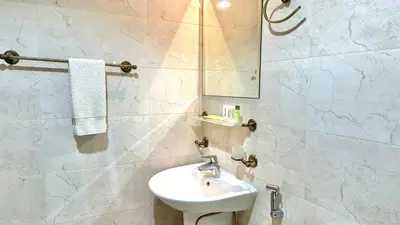 a white bathroom with a sink and a mirror at Charming Studio Retreat in Central JVC by Bhavan Vacation Homes in Dubai