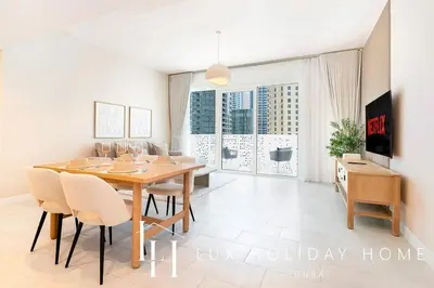 a dining room with a wooden table and chairs at LUX The JBR Garden View Suite in Dubai