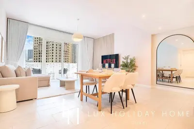 a living room with a table and chairs and a couch at LUX The JBR Garden View Suite in Dubai