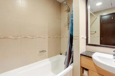 a bathroom with a sink and a bath tub and a sink at Amazing lake skyline view cozy apartment in Dubai