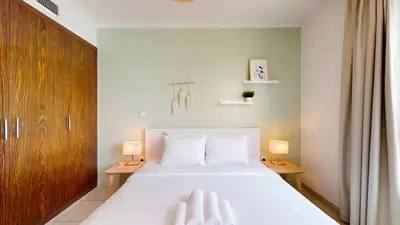 a bedroom with a large white bed with two lamps at The Residences II - One Bed with Burj Khalifa View in Dubai