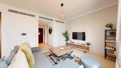 a living room with a couch and a tv at The Residences II - One Bed with Burj Khalifa View in Dubai