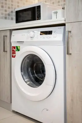 a white washing machine with a microwave on top of it at Seven Palms in Dubai